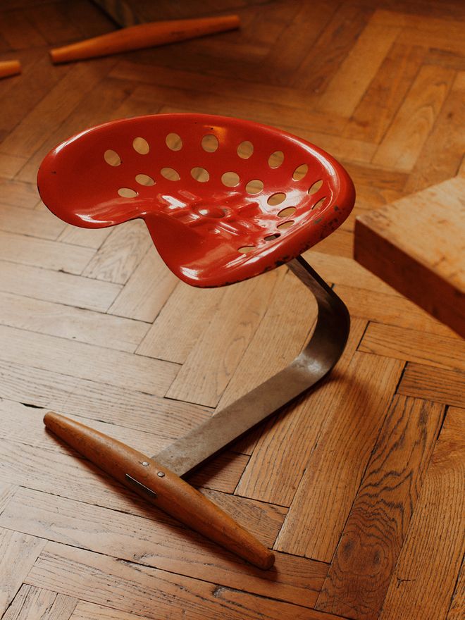 A detail image of Mezzadro stool with a bright red seat