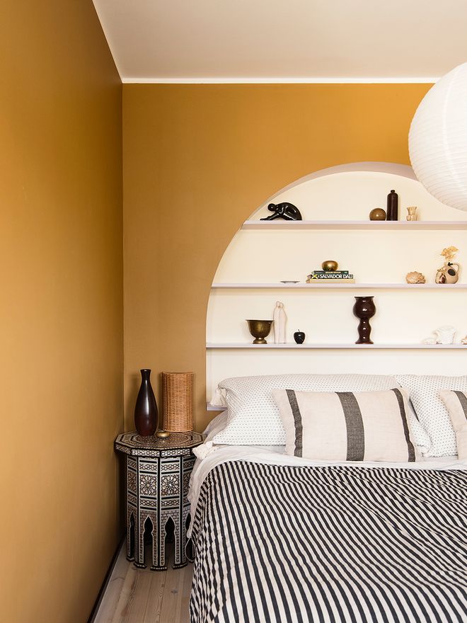 A bedroom with an arched shelf