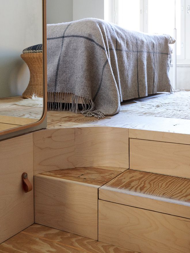A bedroom with storage space under the elevated floor