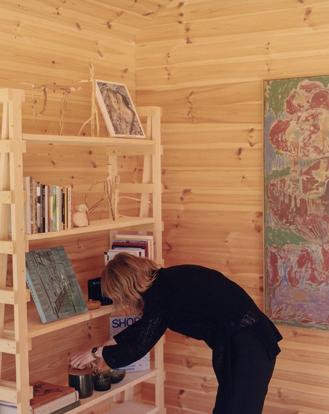 Linn Henrichson arranging a wooden bookshelf