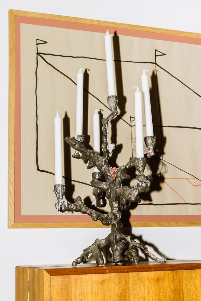Close-up of a candleholder and a piece of art on the wall