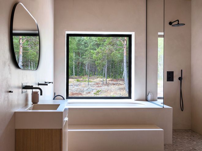 Kylpyhuone, jossa iso ikkuna josta näkyy metsämaisema