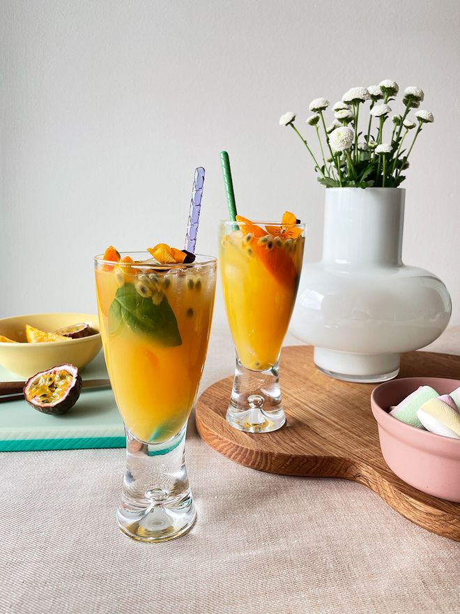 An image of Iittala's Tapio beer glasses, Aalto serving tray, Hay's Rainbow bowl and HAlf & Half chopping board in a table setting.