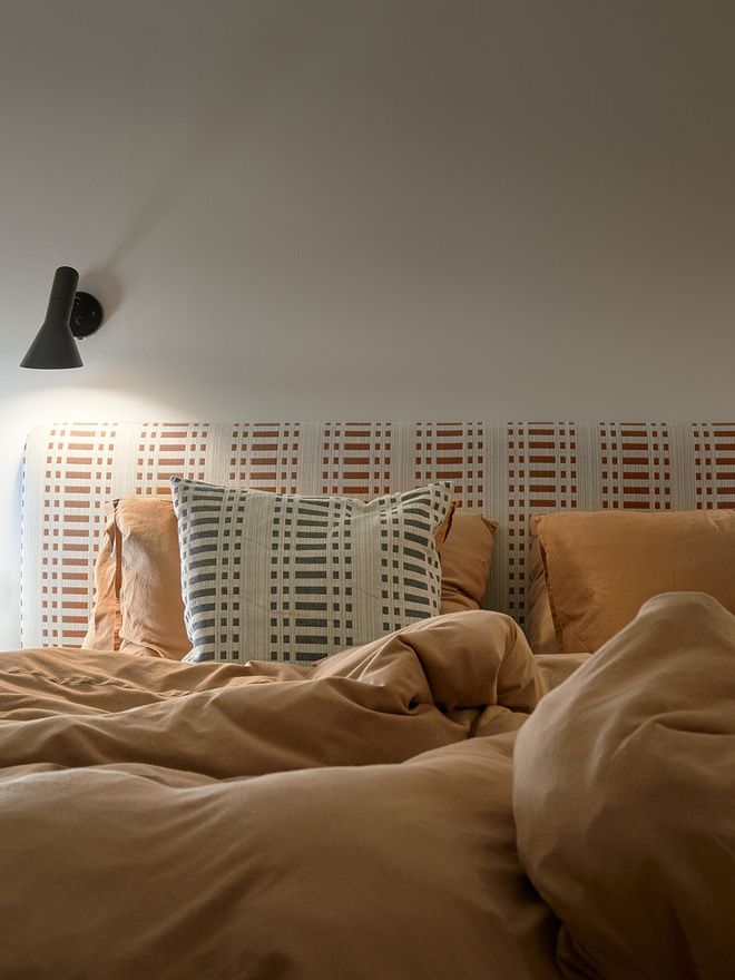 A detail of a bed with a headboard.