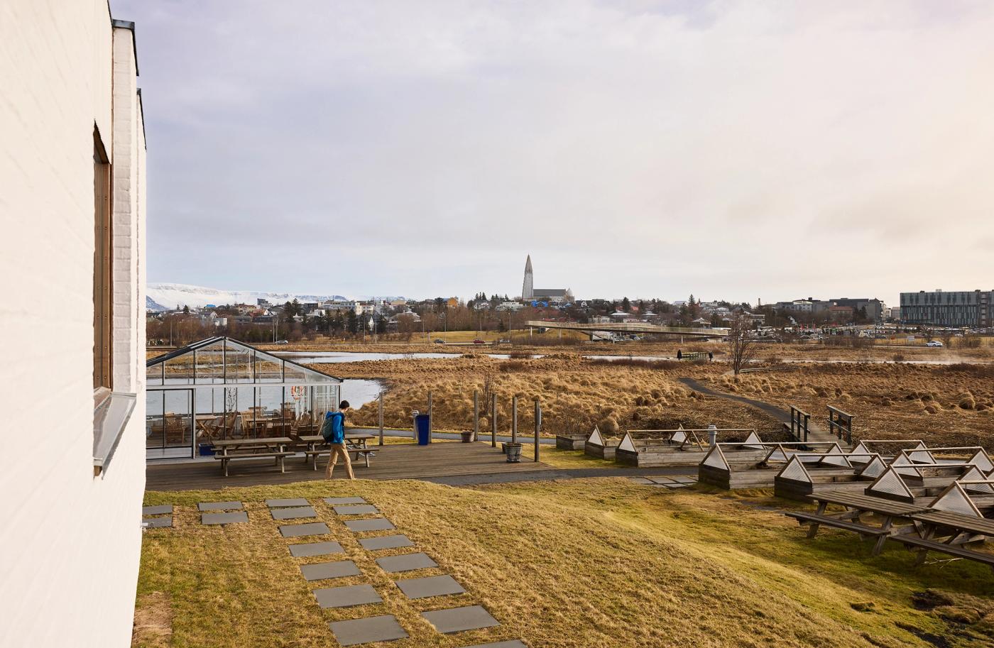 The Nordic House in Reykjavik, landscape image with one person walking in the yard
