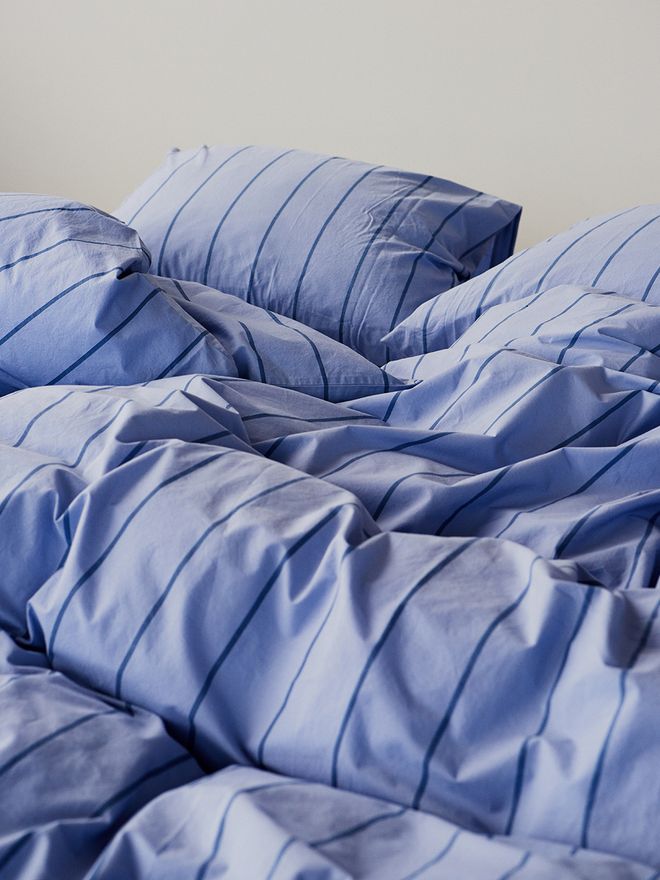 Tekla's striped duvet covers and pillow shams on a bed.