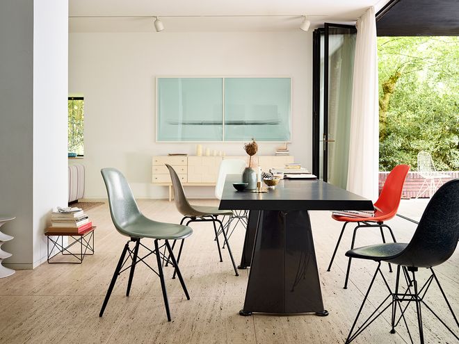 Vitra's Trapezè dining table designed by Jean Prouvé, accompanied by Vitra's Eames chairs.