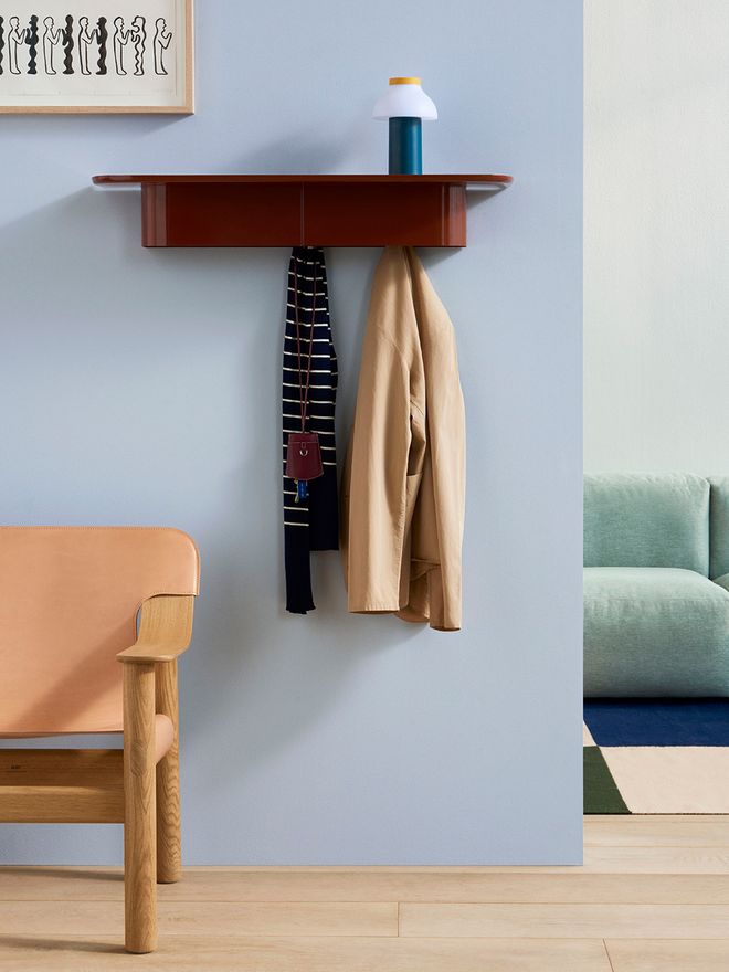 An image of HAY's Korpus wall shelf in brick red as part of the hallway decor.