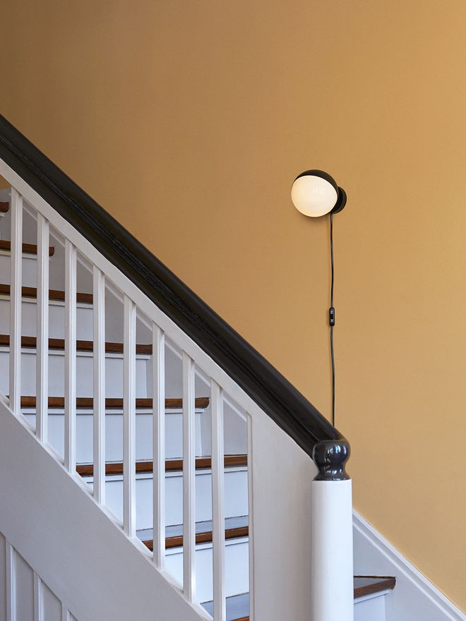 Louis Poulsen VL Studio on the wall of a staircase.
