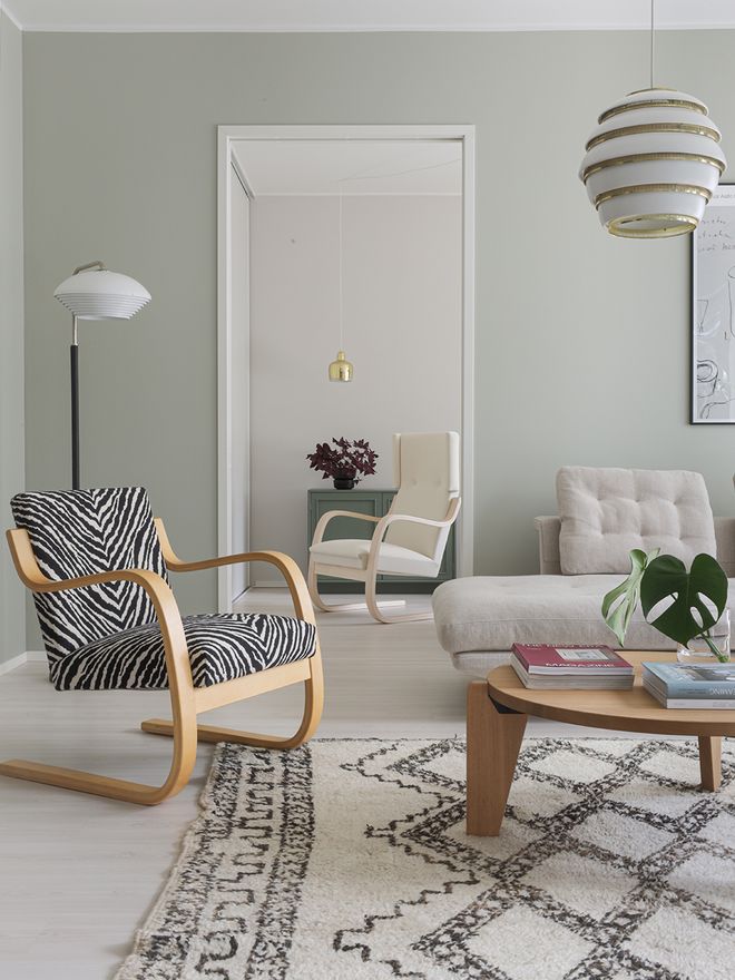 An image featuring Artek's Aalto armchair 402 and A331 pendant lamp or Beehive as part of the living room interior.