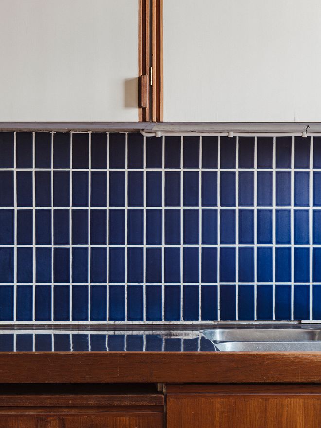 Cobalt blue tile backsplash in the kitchen of Villa Skeppet, combined with teak cabinetry and white surfaces