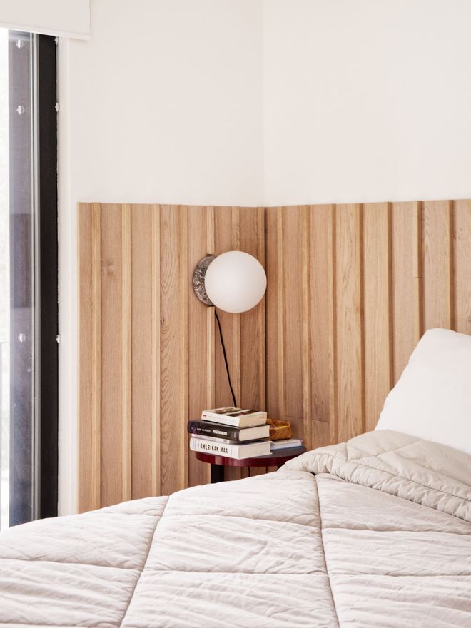 A bedroom with an oak batten wall