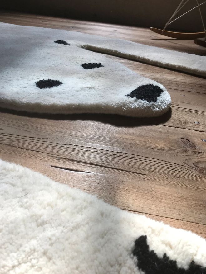 MUM’s white Baby Jääkarhu wool rug on a dark wooden floor