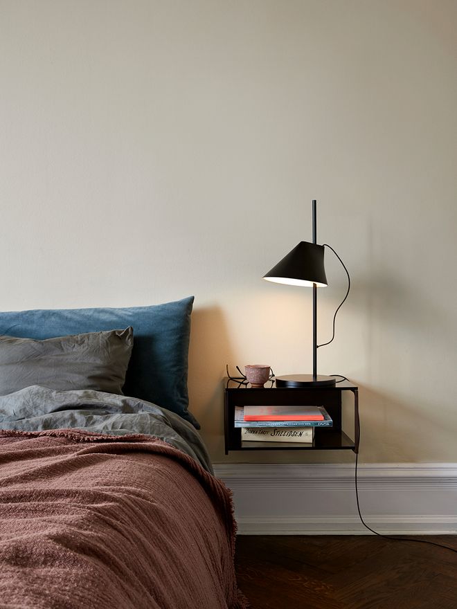 The black Yuh table lamp in a bedroom, on a nightstand.