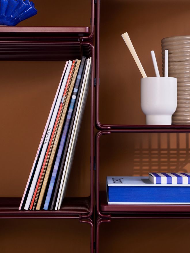 Close-up of a shelving system constructed from Wire modules, filled with books and decorative items