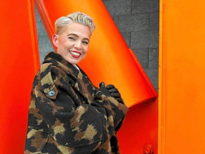 Annu Kemppainen, Executive Director of Helsinki Pride, pictured against an orange background