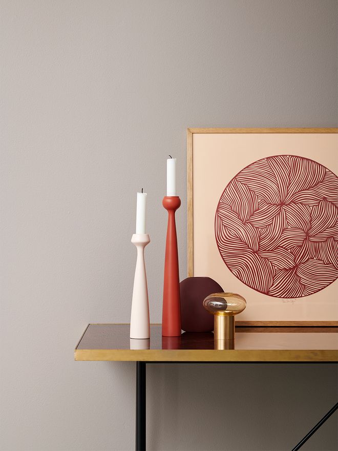 An image of applicata's Blossom candleholders in a light pink and a coral red hue, as part of the living room decor.