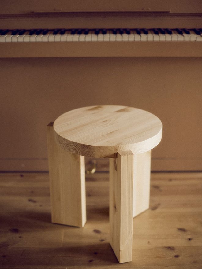 A detail of Vaarnii 001 stool in pine, in front of a piano