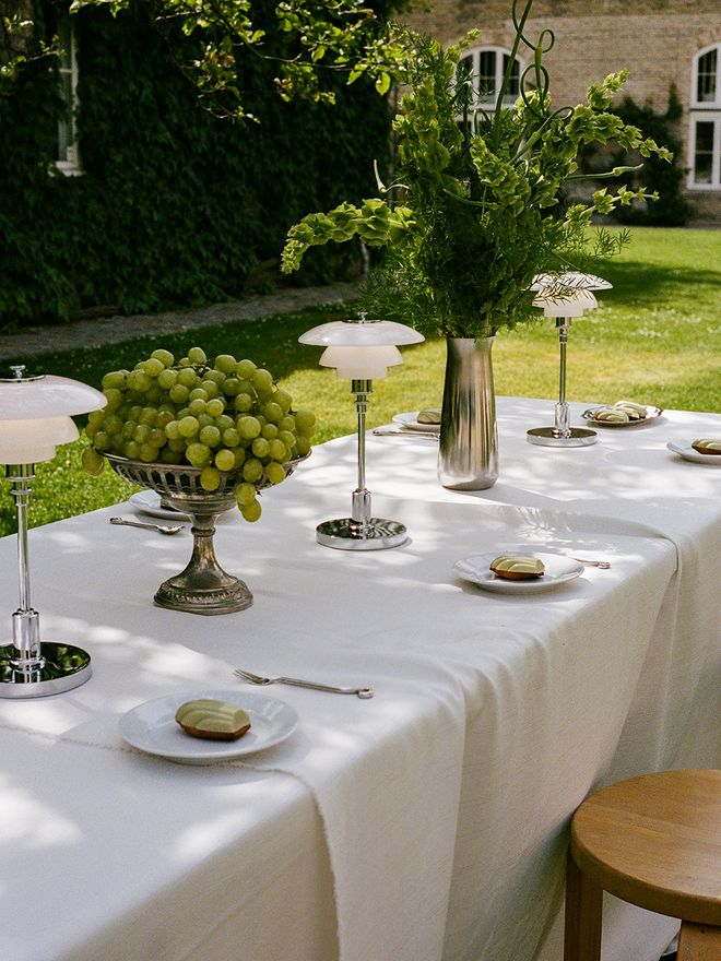 An outdoor table setting with Louis Poulsen lamps