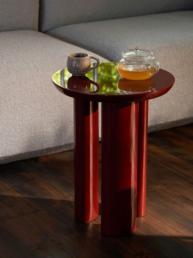 &Tradition’s dark red Tung side table holding a teacup and teapot