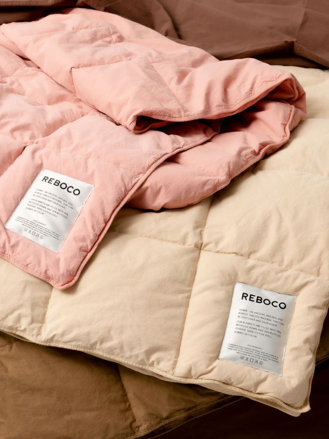 Two duvets, each with a Reboco label sewn onto the edge.