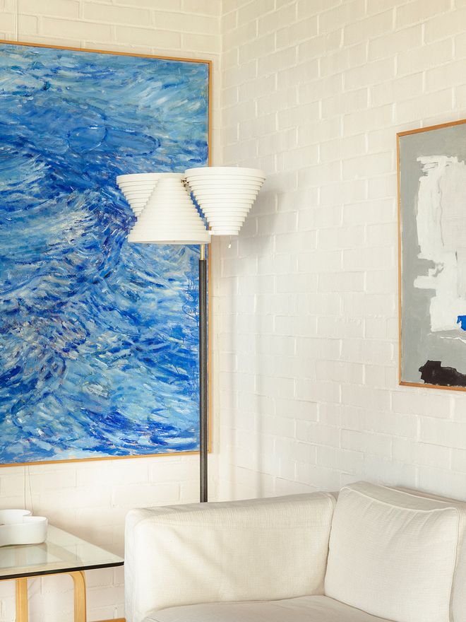 A seascape painting by Roberto Sambonet and an Artek A809 floor lamp in the living room of Villa Skeppet