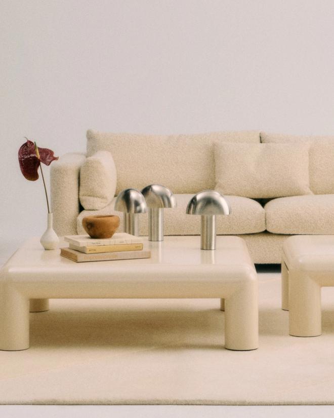 Three brushed steel Aglow table lamps of different heights on a coffee table.