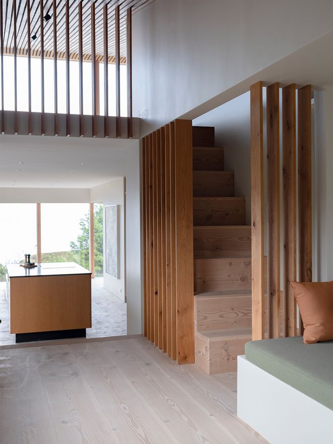 An image of the Holiday home by Þingvallavatn by KRADS architects: a leisure home located in Iceland in the middle of a picturesque scenery. This image features the buildings interior: an airy hallway with slatted walls.