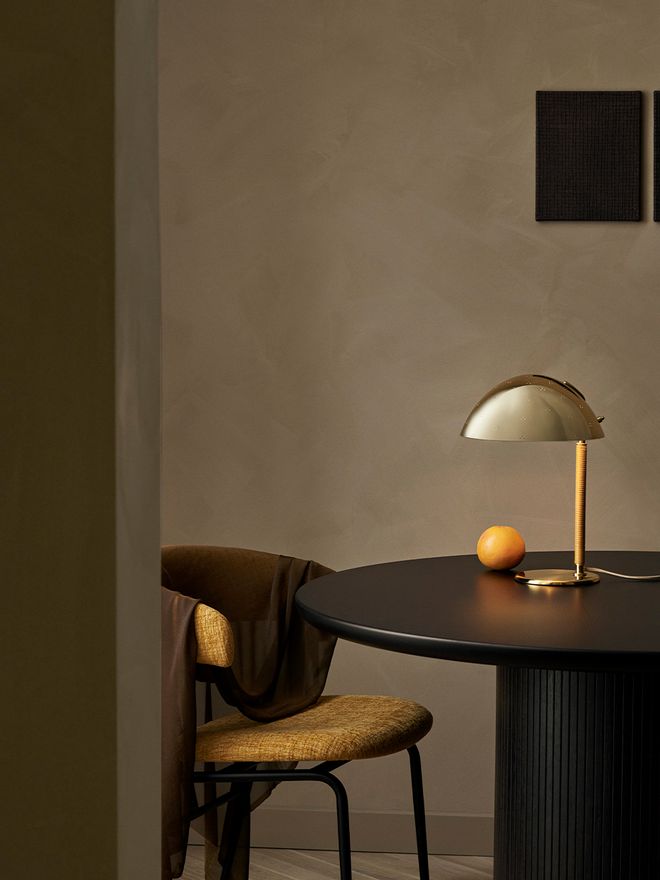 An image featuring GUBI's Paavo Tynell's 9209 table lamp as part of the living room interior.