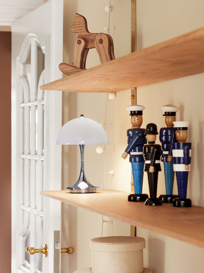 Louis Poulsen Panthella Mini lamp in grey and chrome on a shelf.