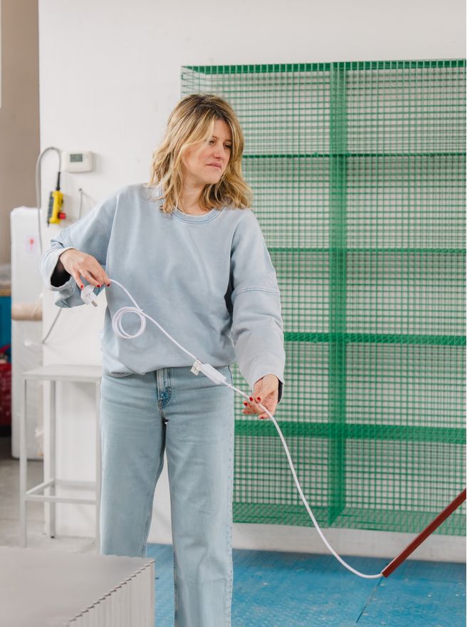 Fien Muller holding a white lamp cord