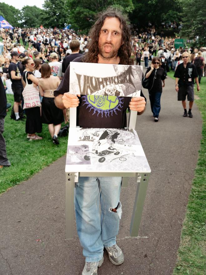 Fredrik Paulsen holds up the graphic-printed prize chair to show its design
