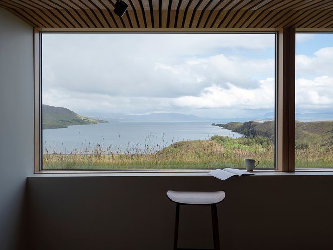 An image of the Holiday home by Þingvallavatn by KRADS architects: a leisure home located in Iceland in the middle of a picturesque scenery. This image features the buildings interior: a window recess with a view towards the lake.