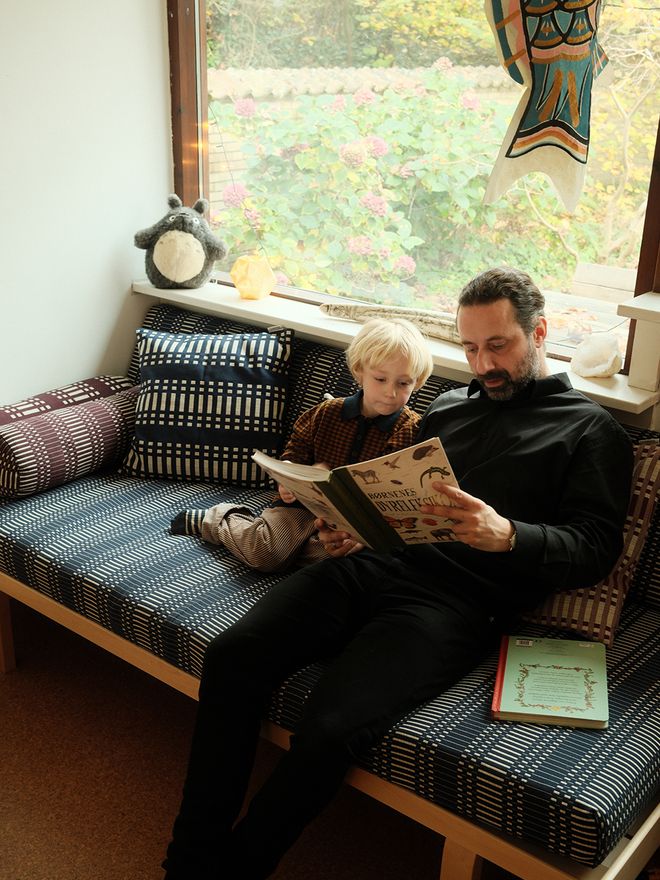 Martin Kallesø with his child, sitting on Artek daybed