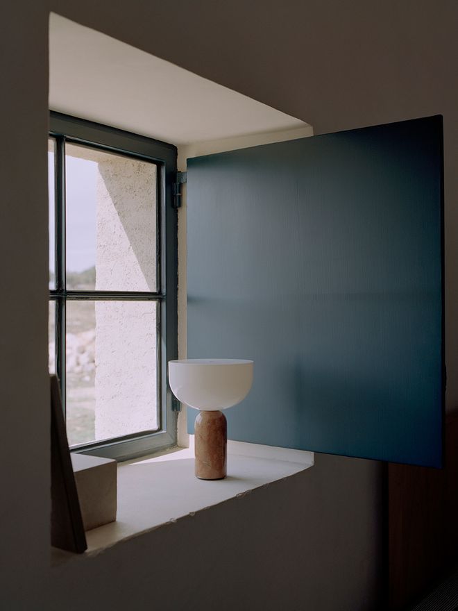 Image featuring the Kizu portable table lamp by New Works on a window sill, as part of the living room interior.