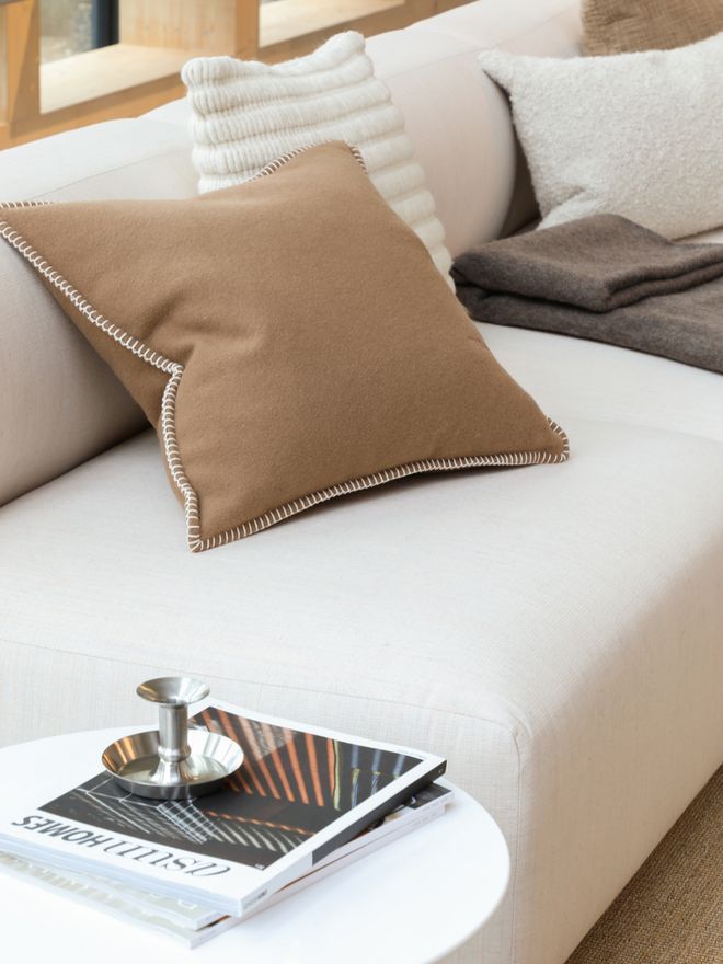 A sofa dressed with cushions in autumnal tones