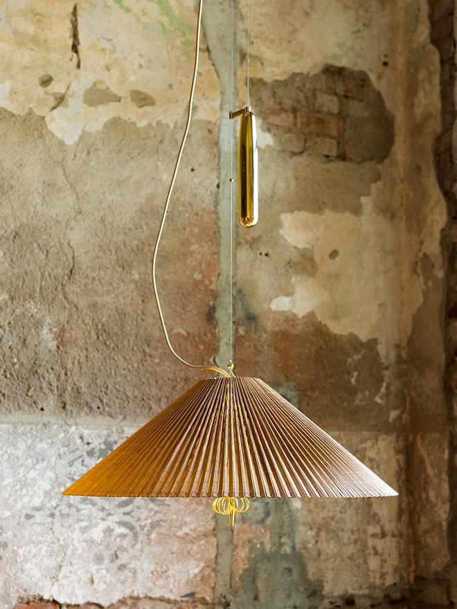 An image featuring GUBI's Paavo Tynell's 1967 lamp as part of the dining room interior.