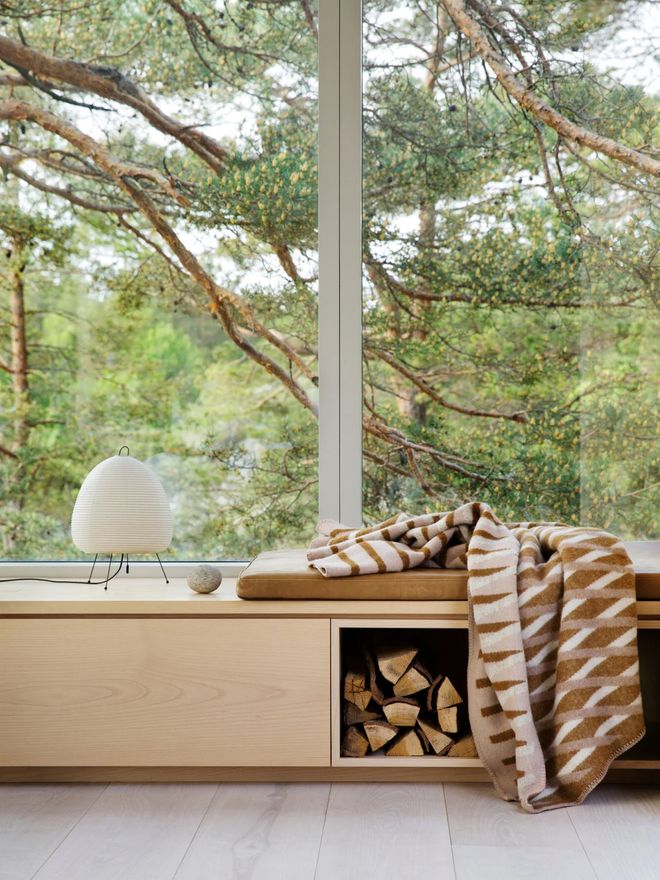 Scandinavian-style reading nook on a windowsill in front of a large window