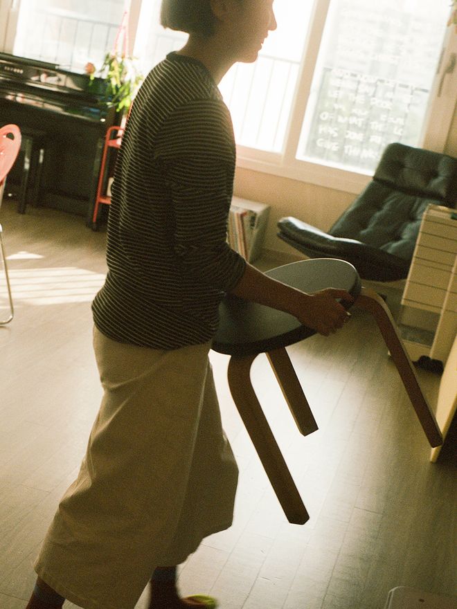 Woman carrying an Artek stool