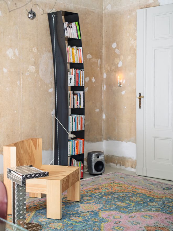 The pine Vaarnii 005 lounge chair in the living room, in front of a black bookshelf