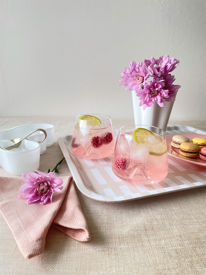 An image of Normann Copenhagen's Whisky glasses, Artek's Siena tray, Iittala's Aalto bowl and ferm LIVING's Fein ice cube spoon in a table setting.