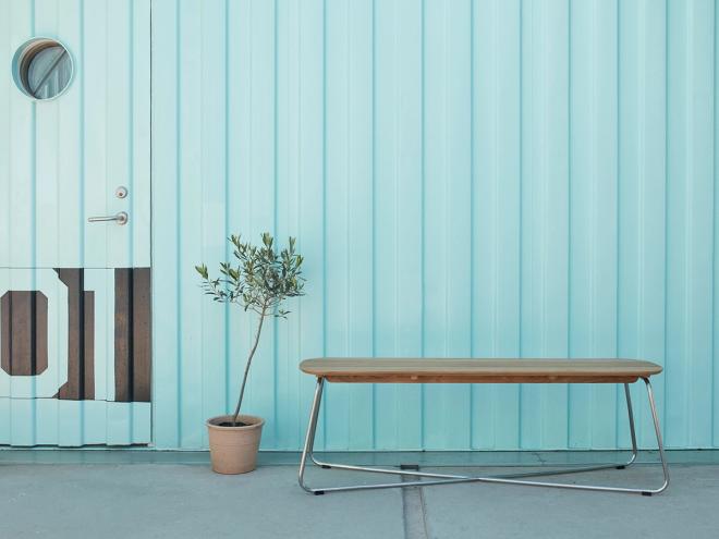 Skagerak's Lilium bench against a turquoise background.