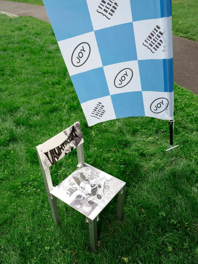 A checkered racing flag hangs above the Vauhtikisat Chair One prize chair, waiting for its winner in the middle of the buzzing Sinebrychoff Park crowd.