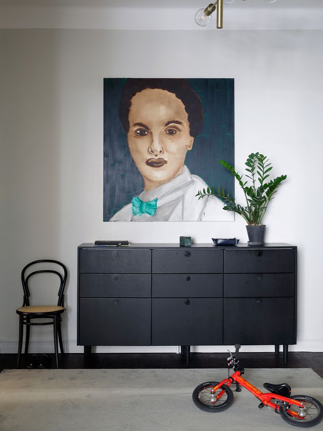 Black sideboard, red bicycle and a large portrait
