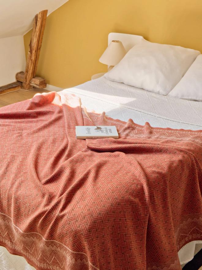 A bed in a bedroom with yellow walls