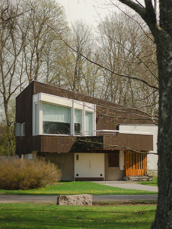 Exterior of Villa Skeppet in Ekenäs, Finland — a modernist house designed by Alvar Aalto, with dark corrugated metal cladding, large horizontal windows, and a sloping roofline