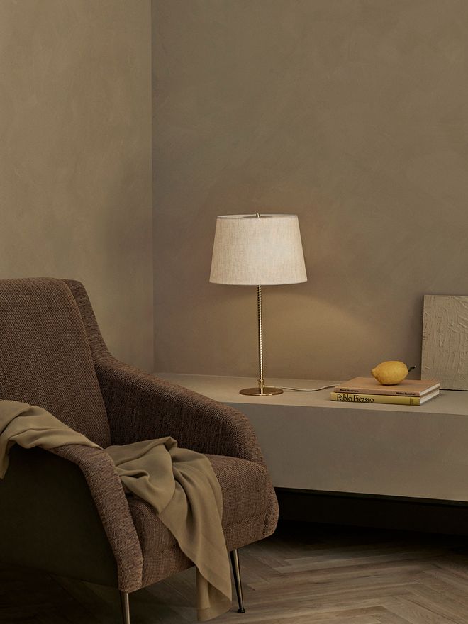 An image featuring GUBI's Paavo Tynell's 9205 table lamp as part of the living room interior.