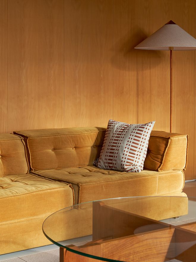 A yellow sofa and a wall lamp