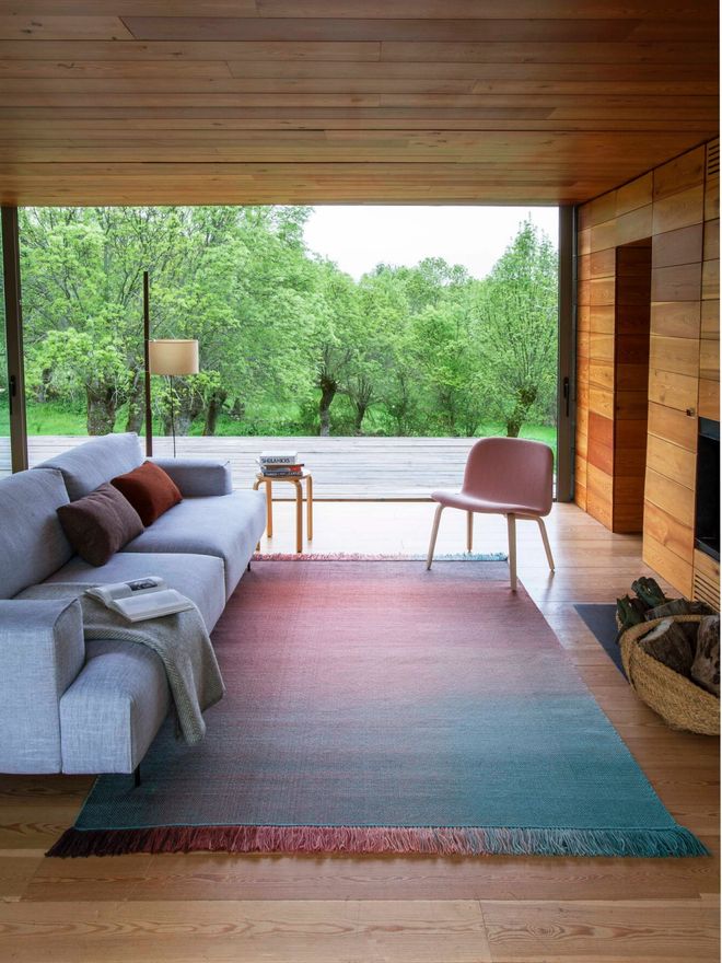 A living room with Nanimarquina’s gradient Shade Palette 2 wool rug on the floor