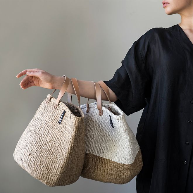 Mifuko's Kiondo baskets with handles, held by a woman.